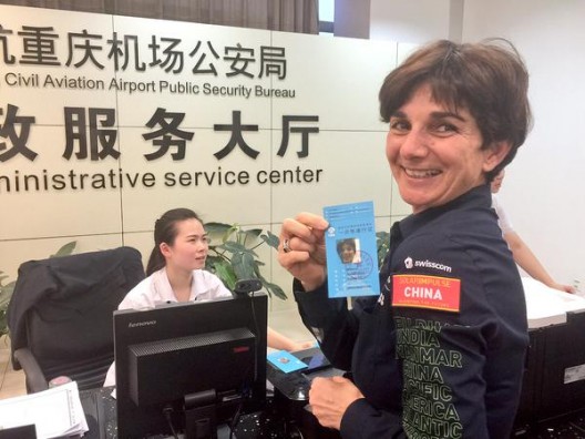Bertrand Piccard's wife, Michelle, happily displays her pass that allows her to be on hand for SI2's landing at Chongqing.  Logistics for this trip must be daunting